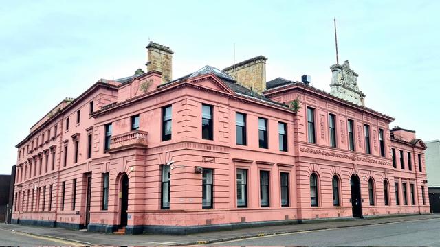 A large Classical style Victorian police building, which has, more recently, been painted pink.