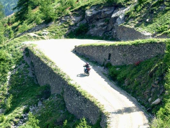 view to the north ramp of the Colle delle Finestre, a motorbike is riding up