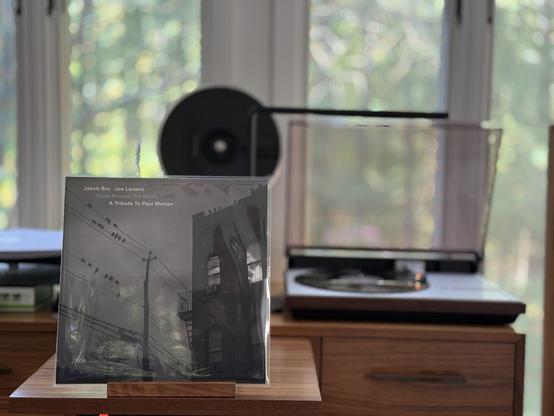 Jakob Bro & Joe Lovano: Once Around the Room - A Tribute to Paul Motian LP cover.

A foggy night, black and white, with a two-story building to the right, and a power line to the left. There are birds on the lines, and other buildings can be seen through the fog.

The black LP plays on a vintage, restored Bang & Olufsen Beogram 4000 linear-tracking turntable to the right.