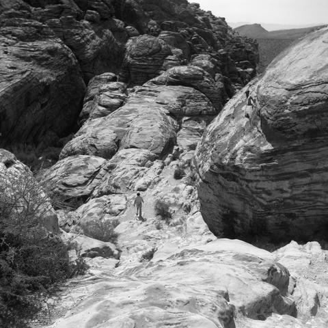 A woman walking up the boulder in Calico Hills.