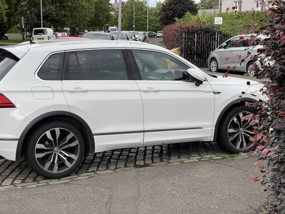 White SUV over parking on a pedestrian pavement.
