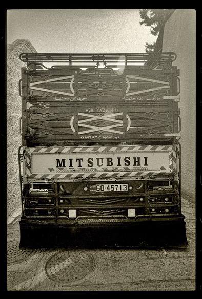 A black and white photo of a Mitsubishi Dyna truck from the back. In hand lettering it says “Abu Yazan!!”