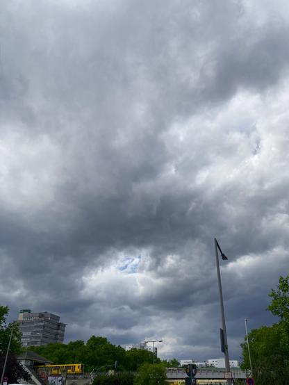 Stürmische Wolken (und ein bisschen blauer Himmel) über einer oberirdischen U-Bahnstrecke.