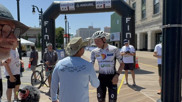 Philipp Kaider shaking hands with a spectator after winning the 2025 Race Across America.