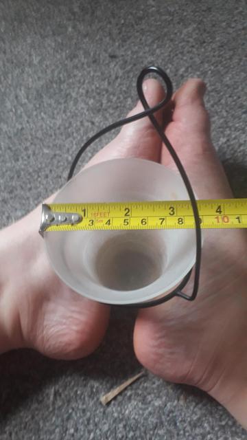 The top of one of the votives balanced between my feet with a tape measure showing the lip is 3.5 inches across.