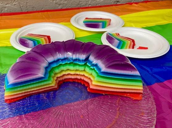 A rainbow of ribbon jello sits on rainbow-patterned tablecloth. A few plates with servings are nearby. Photo from the Buddhist Church of San Francisco's Facebook page.