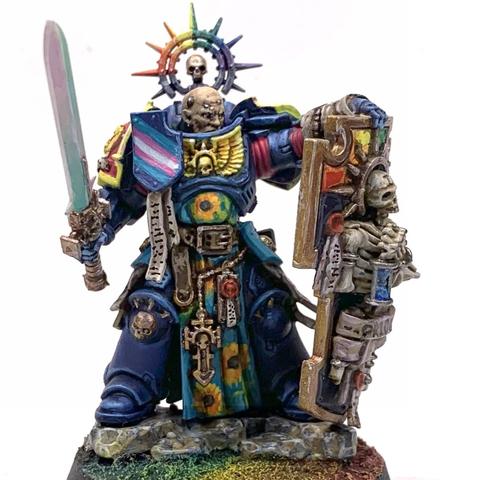 Large warrior in dark blue armor with pansexual color (blue, yellow, and magenta) decorations. He carries a pearlescent sword and a large bulwark shield with rainbow colors behind a skeleton holding an hourglass and wrapped in scrolls that say "Pride". His tabard has sunflowers over light blue. He has a rainbow halo over his bear head, which stares out beyond the shield in defiance.