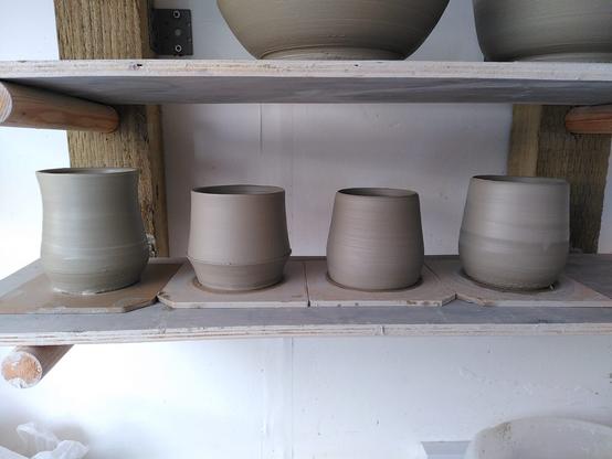 4 clay mug bodies on their bats after throwing