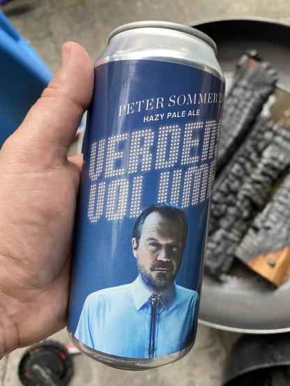 Ugens øl - der er en reklame for Peter Sommers nye album verdens Volumen - holdes op over et vådt, slukket bål