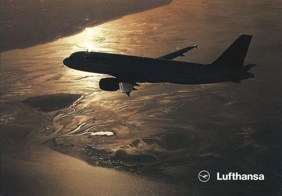 Sun sets across the landscape making a yellowish glow. The plane is silhouetted by the light