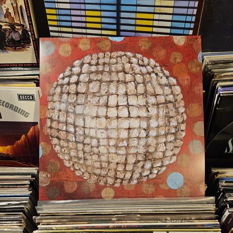 Album cover features a painting of abstract,  spherical design, sort of like a disco ball, on a red background with colorful dots.