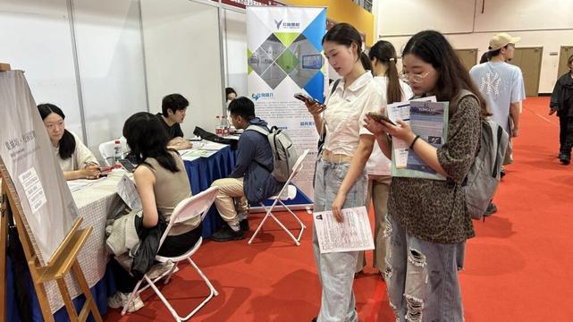 Students looking at a job ad at an employment fair in Shanghai.