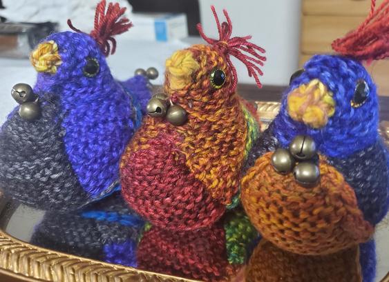Three colorful chickies with 3 bells clustered at the neck, in purple, red, orange, black