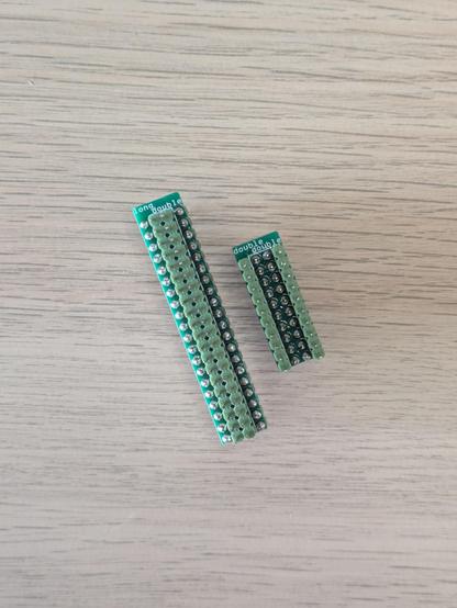 A photo of two small circuit boards. They are long double rows of electrical pins. One is labeled "long double" and the other "double double".