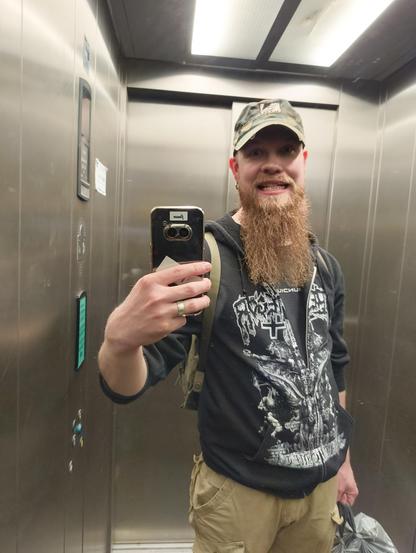 Hississä peilin kautta napattu parrakkaan mieshenkilön selfie.