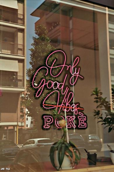 Farbfoto. Im Schaufenster des Restaurants "Only Good Vibes POKÈ" spiegeln sich die gegenüberliegenden Gebäude, Autos und Bäume. Vom Restaurant selbst sind nur eine Stellefläche mit einer Topfpflanze und zwei Kübeln erkennbar. Leica IIIg mit 50 mm Summitar auf Kodak Gold.