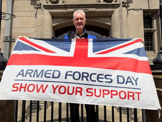 Cllr Gordon Munro with an Armed Forces Day flag