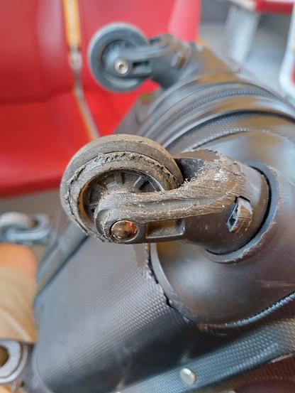Photo of a worn out wheel of a trolley case.