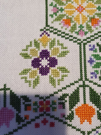 Yet another photo of the floral hexagons cross stitch, a work in progress, the small purple flower I stitched the other day now has some light green and dark green leaves surrounding it.