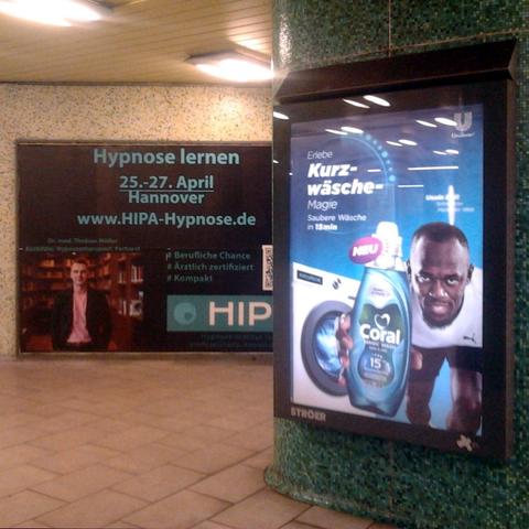 Werbung in der hannöverschen U-Bahn-Station Kropcke: »Hypnose lernen« und »Entdecke Kurzwäsche Magie«.