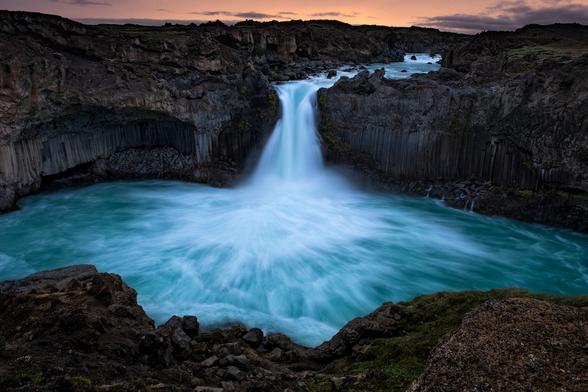 The majestic Aldeyjarfoss waterfall in the north highlands of Iceland at sunrise.