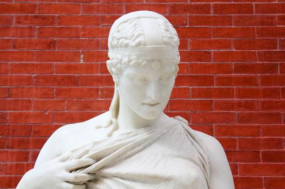 Sappho, Count Prosper d'Epinay, ca. 1895 displayed at The MET in New York City, NY. A portrait photo of the white marble figure of Sappho in front of a red brick wall.

Source text: 
https://lsa.umich.edu/content/dam/kelsey-assets/kelsey-documents/2021-Poetry-Blast.pdf
https://www.thecollector.com/who-was-sappho-of-lesbos/