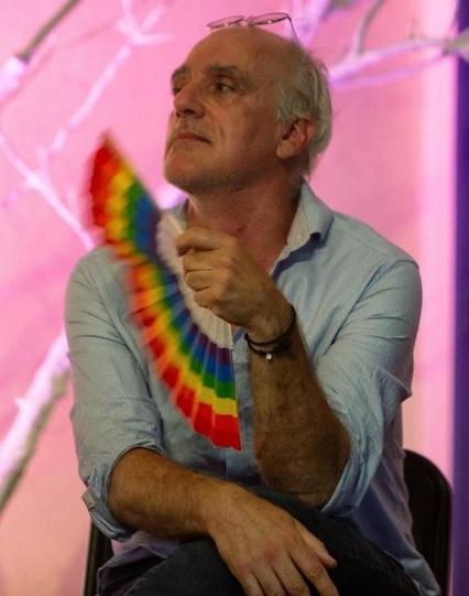 Philippe Poutou qui s'évente avec un éventail aux couleurs lgbt.
