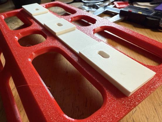 Back side of the cage showing the part that goes against fork nestled into notch. The part has 3 holes for mounting and two indents where a strap can go through.