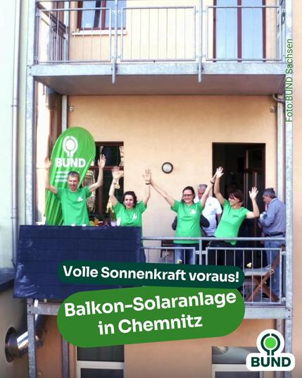 Mitarbeitende des BUND Sachsen stehen jubelnd auf einem Balkon mit installierten Solarmodulen und grünem BUND-Banner. Text im Bild: „Volle Sonnenkraft voraus! Balkon-Solaranlage in Chemnitz“.