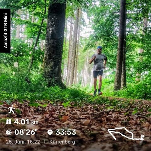 Person joggt durch einen grünen Wald in Sportkleidung und Mütze. Links im Bild steht 'Amazfit GTR Mini'. Unten sind Joggingdaten eingeblendet: 4,01 km in 33:53 Minuten, durchschnittlich 08:26 min/km. Datum 25. Juni, Uhrzeit 16:22, Ort Kürrenberg. Rechts unten Karte der Laufstrecke.