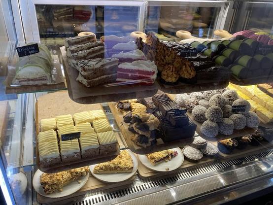 A bakery display case filled with various cakes and pastries.