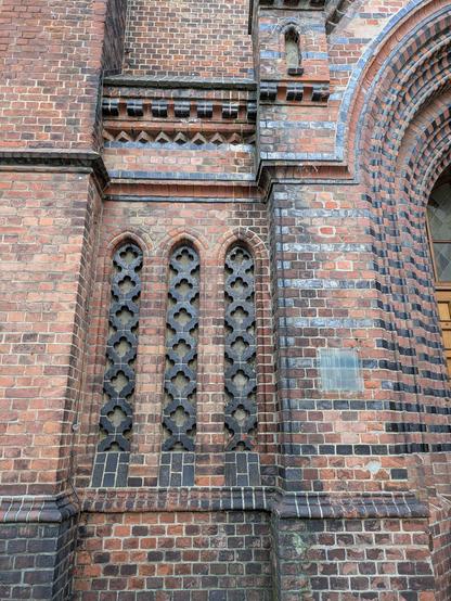 Backstein-Ornamente neben dem Portal - einige Steine sind dunkel lasiert, andere speziell geformt