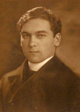 Vintage sepia-toned portrait of a man with short hair, wearing a dark jacket and white shirt, looking directly at the camera.