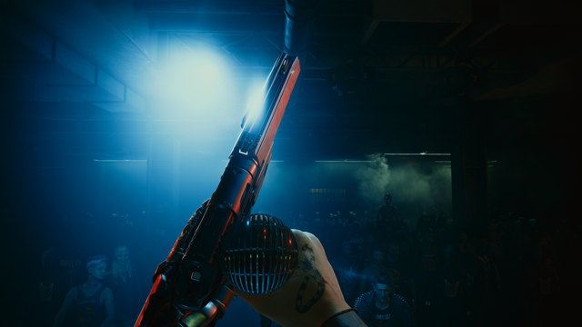 POV of person grabbing a mic on stage with a gun in the other hand in front of a crowd