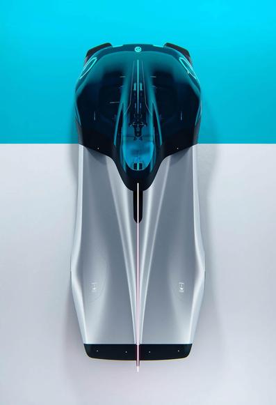 Futuristic racing car concept with sleek silver body and transparent canopy, set against a blue and white background.