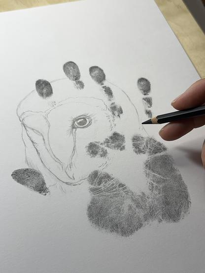 Hand print in graphite with the beginnings of a barn owl portrait