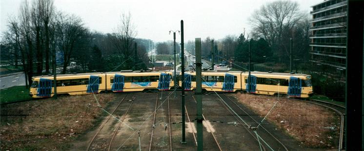 Un couplage de motrices PCC en livrée jaune avec losanges bleus au niveau des portes caractéristique des années 1990 sur la boucle de retournement à Esplanade. A gauche, c'est l'autoroute A12 vers Antwerpen qui est visible.