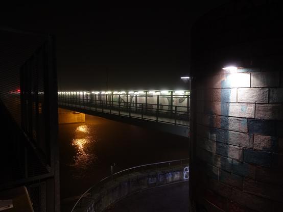Zug in Langzeitbelichtung auf Brücke über Mündung zweier Flusskanäle bei Nacht