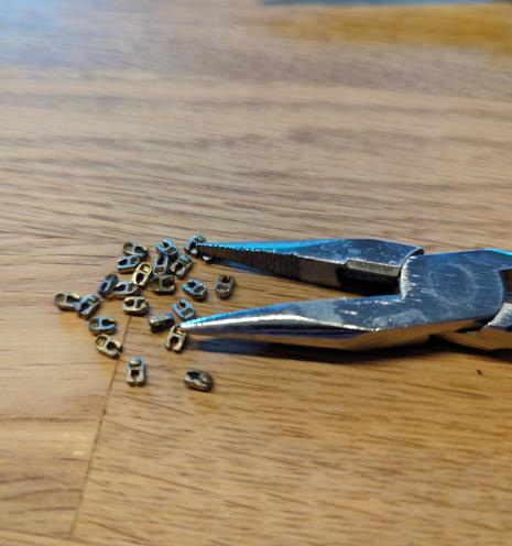 Spitze Zange mit vielen einzelnen metallenen Reißverschlusszähnchen