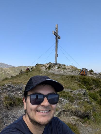 I am sitting near the peak's cross and smiling into the camera.