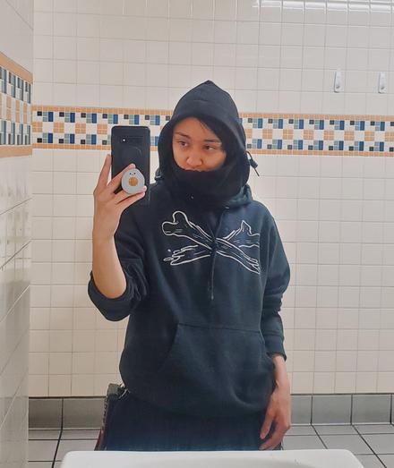 mirror selfie of user in black balaclava and black hoodie with crossed bones on the front