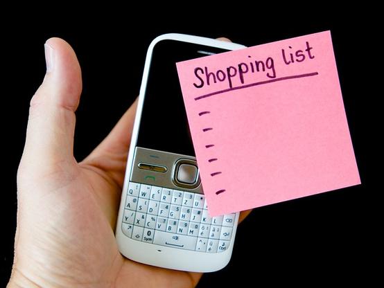 picture of a hand holding a phone and a sticky note labeled "shopping list"