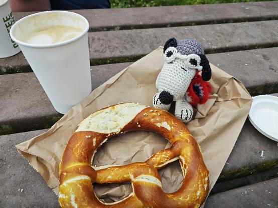 Snoopy genießt Caffee Latte und Butterbrezel.