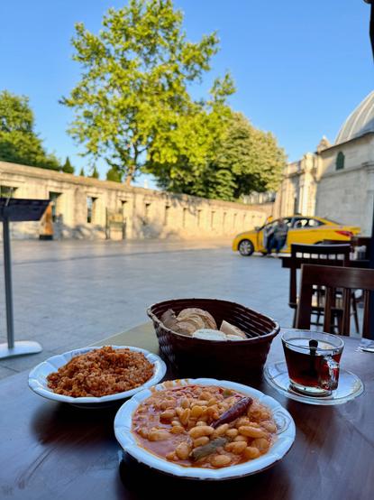 a plate of beans and a plate of bulgar pilaf in an outdoor restaurant
