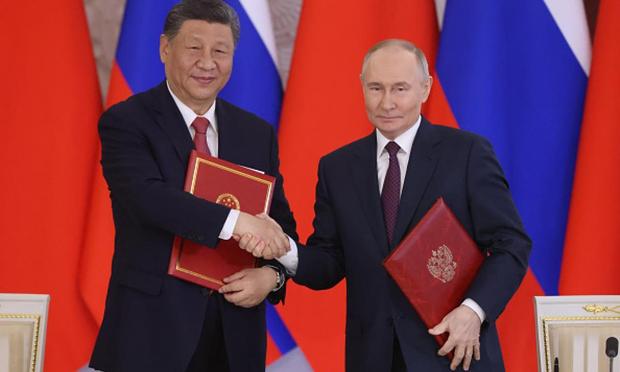El Presidente ruso Vladimir Putin intercambia documentos con el Presidente chino Xi Jinping, en un acto en marzo de 2023 en Moscú (Rusia). (Getty Images)
