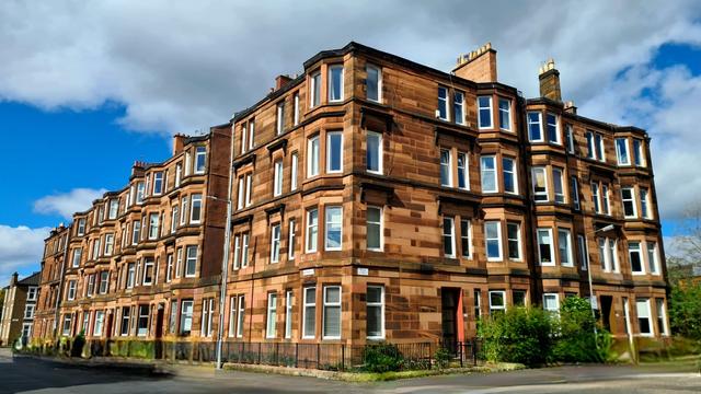 A four-storey red sandstone Glasgow tenement.