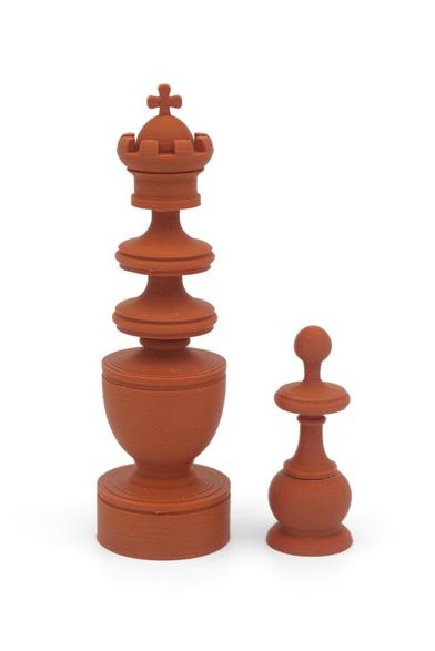 king and pawn of a 3d printed chess set against a white background. peieces are printed in Carmale matte PLA.