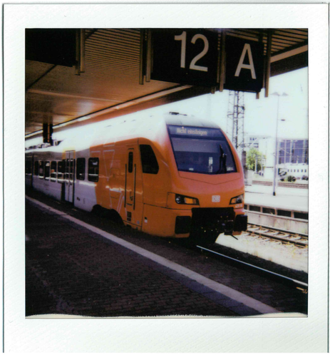 a polaroid picture of a flirt train in the red-white livery of süwex