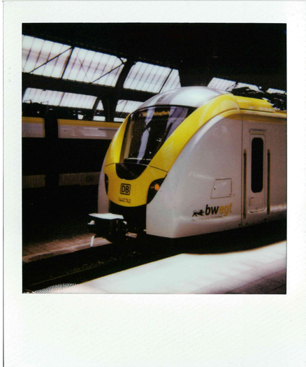 a polaroid picture of a br440 in karlsruhe hbf in the bwegt livery