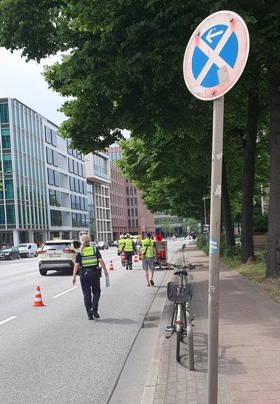 Helfer sperren auf der Willy-Brandt-Straße mit Pylonen eine Spur fürs Rad ab